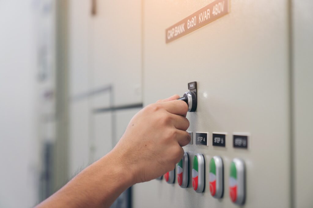 Electrical engineer man checking voltage and test at the Power Distribution Cabinet in control room